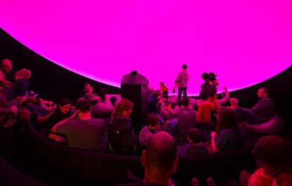 People prepare to enjoy a planetarium show.