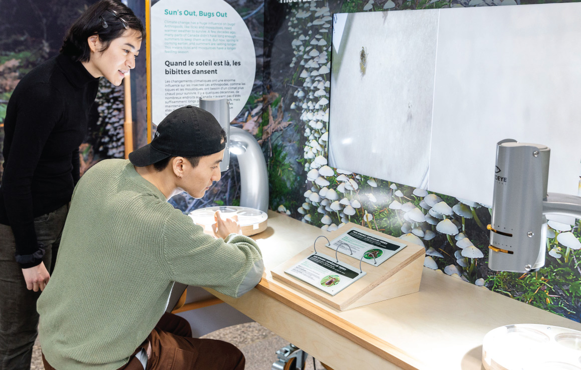 Two young adults interact with an exhibit in Our Climate Quest.