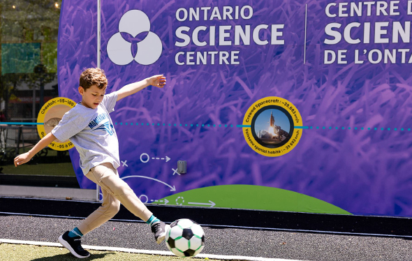A boy kicks a soccer ball.