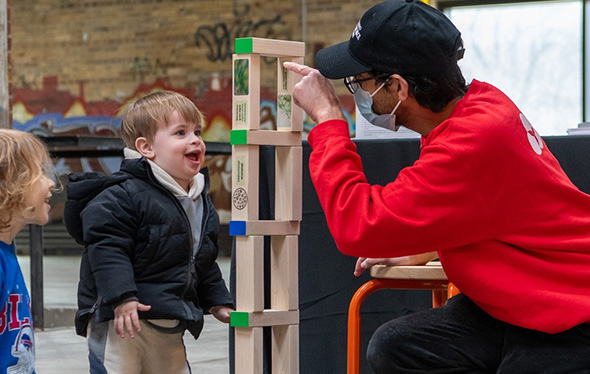 A man and two kids play Jenga.