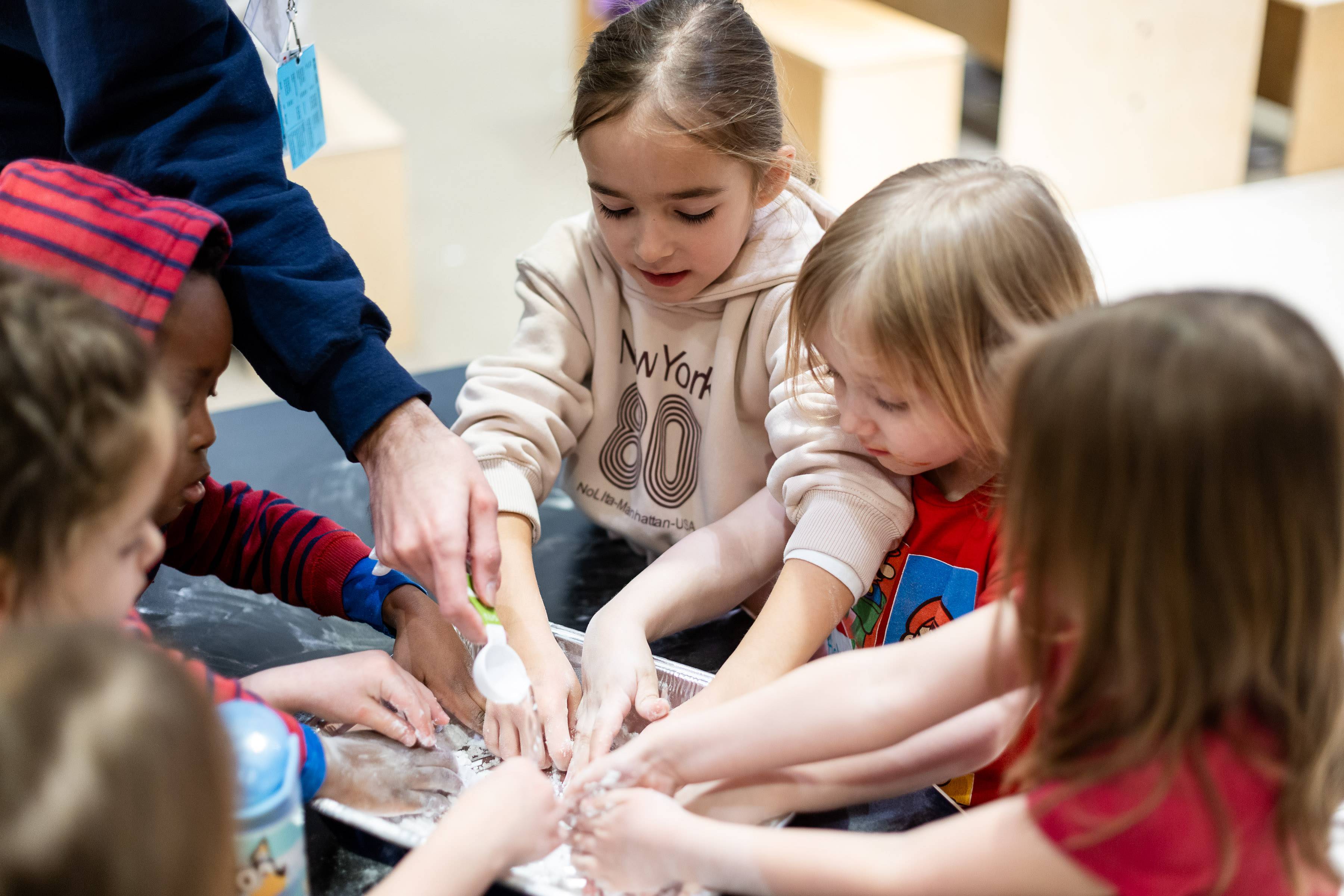 a group of children play with a hands-on science experiment.