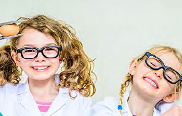 Two smiling young girls in glasses.