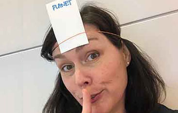 A woman with a piece of paper attached to her head that says Planet on it.