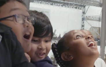 Three children with their mouths open in wonder at the Science Centre.