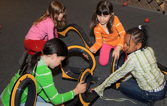 Children play with balls and track.