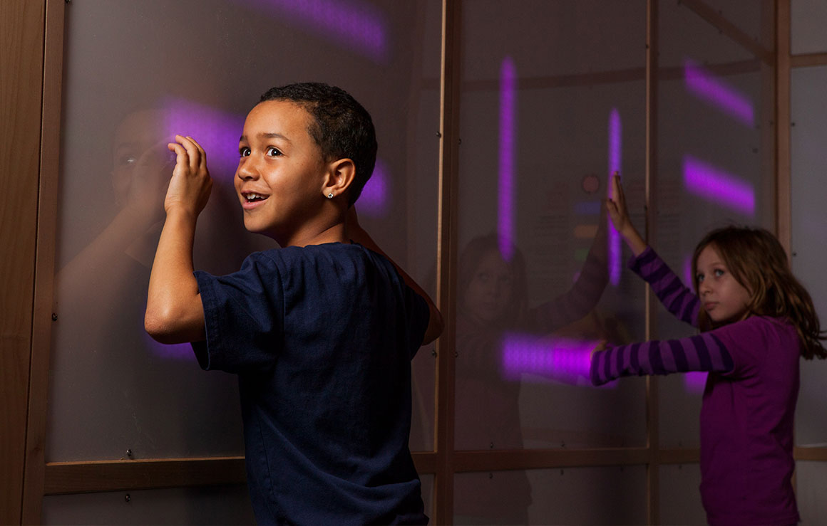 Children play with a wall of sound panels.