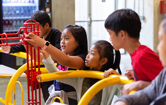 Children play with the kinetic sculpture.