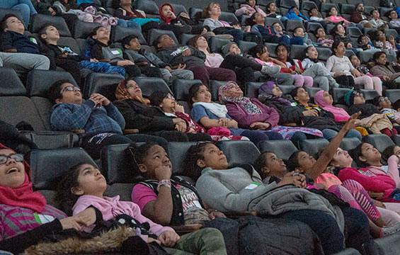 A group of students seated in the OMNIMAX Theatre.