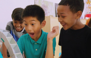 Three students experiment with structures.