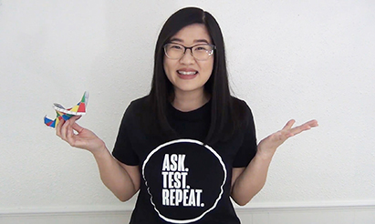 A woman holds her hands out while explaining a science topic.