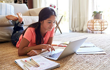 A young woman learns while working at a laptop.