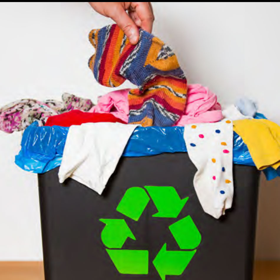 A person putting fabric into a recycling bin.