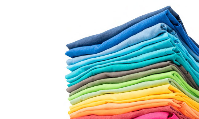 A pile of fabric arranged by colour according to the rainbow.