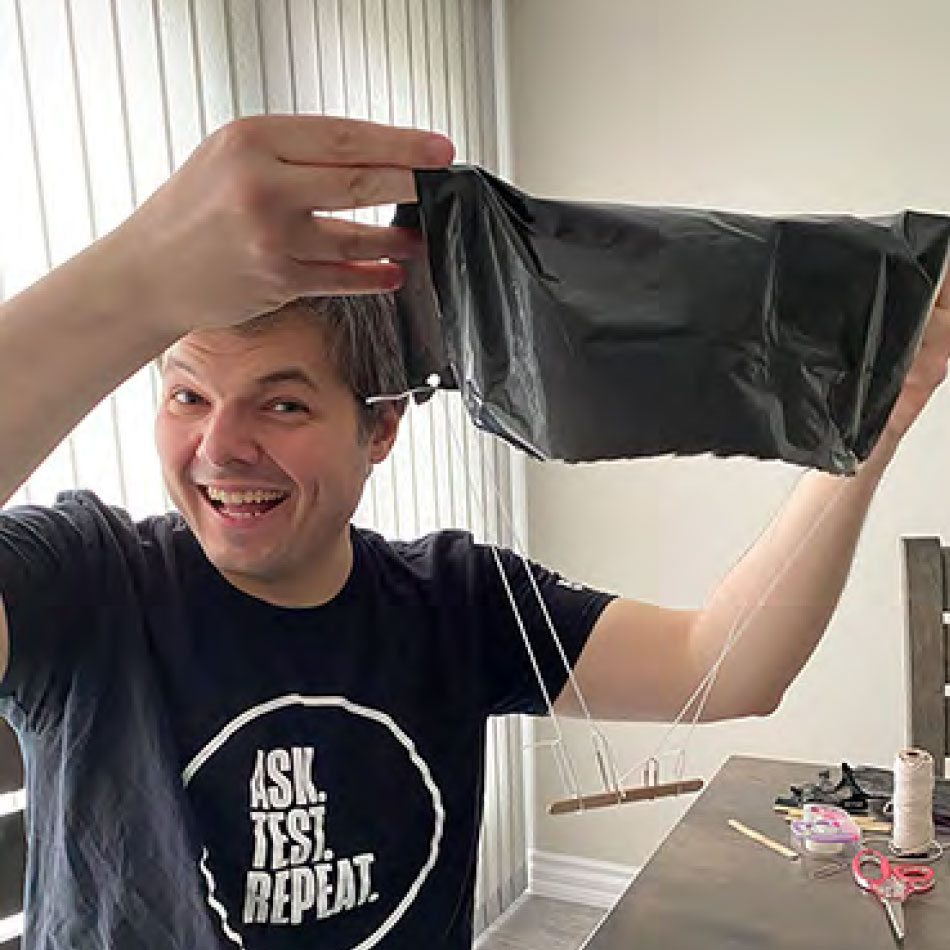 A man holding up a homemade parachute.