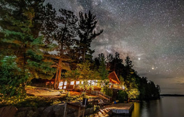 A resort in the woods under a night sky.
