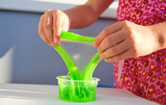 A child stretches out green slime.