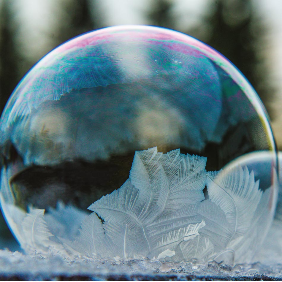 Two frozen ice orbs sit in the snow.