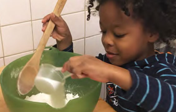 A child mixes ingredients in a bowl.