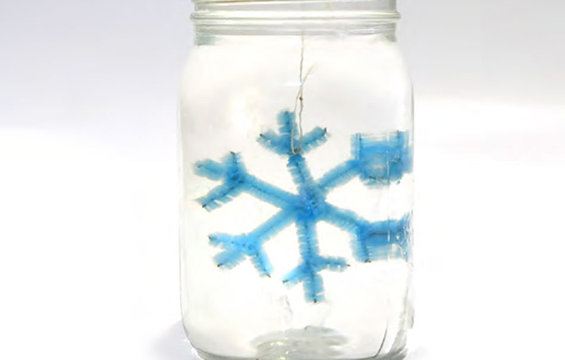 A crystal snowflake growing in a jar.