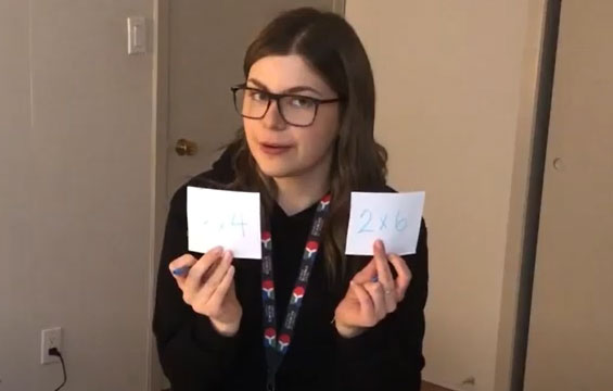 A Science Centre host holds up two pieces of paper.