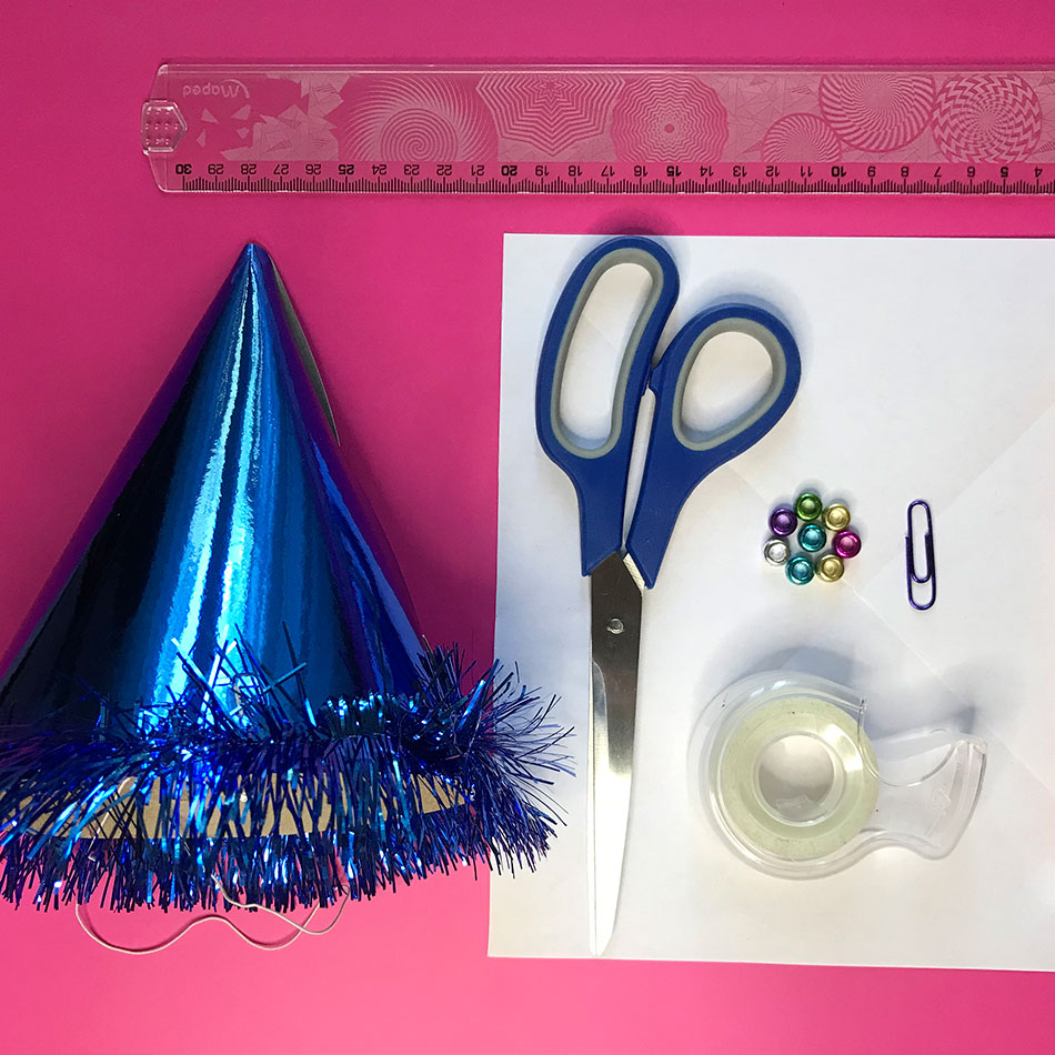 Home materials including tape, scissors and a party hat.