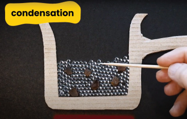 A diagram made out of cardboard demonstrates condensation.