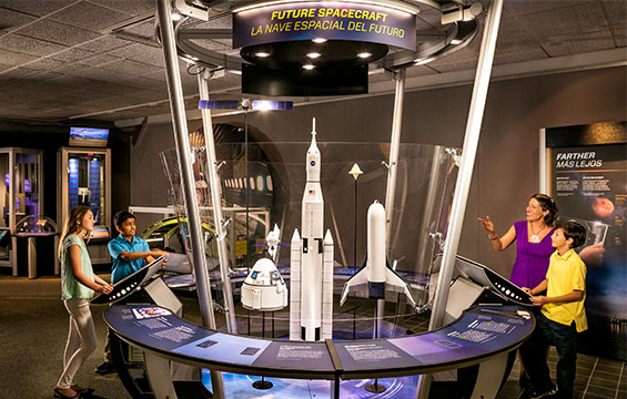 People looking at an exhibit of future spacecraft.