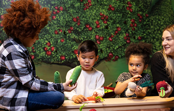 Children playing with toy fruits and vegetables.