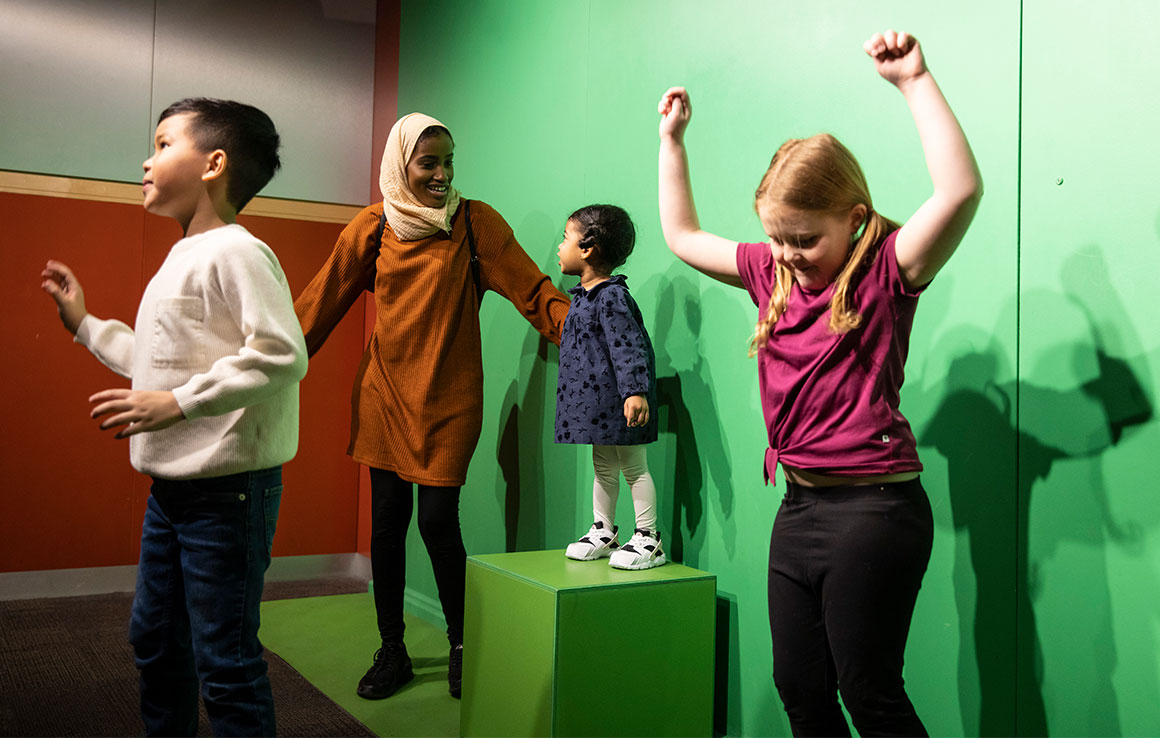 Children dancing in front of a green screen.