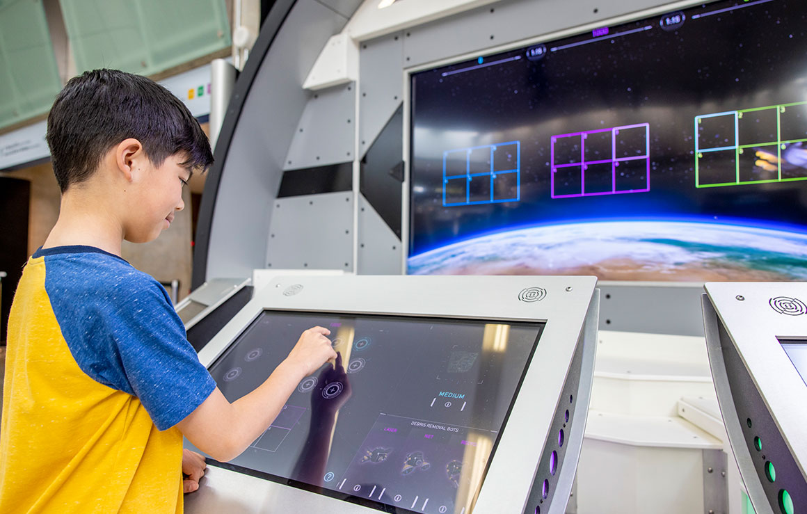 A boy using a touchscreen exhibit.