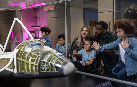 People looking at a model space shuttle.