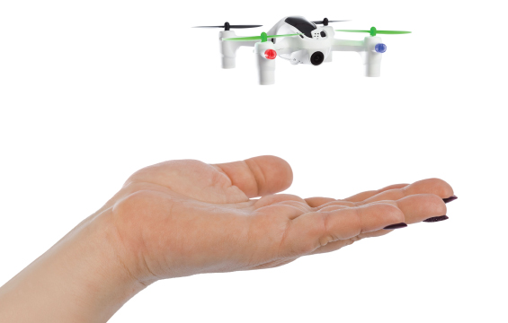 A small drone hovers above a hand.