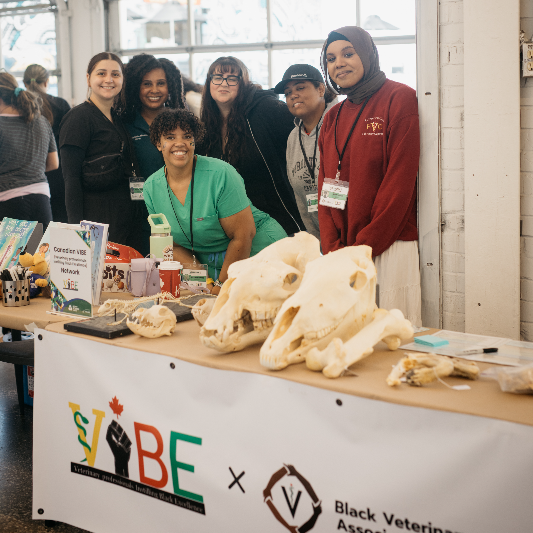 A doctor and a group of volunteers pose at an event booth.
