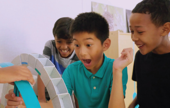 Three students experiment with structures.