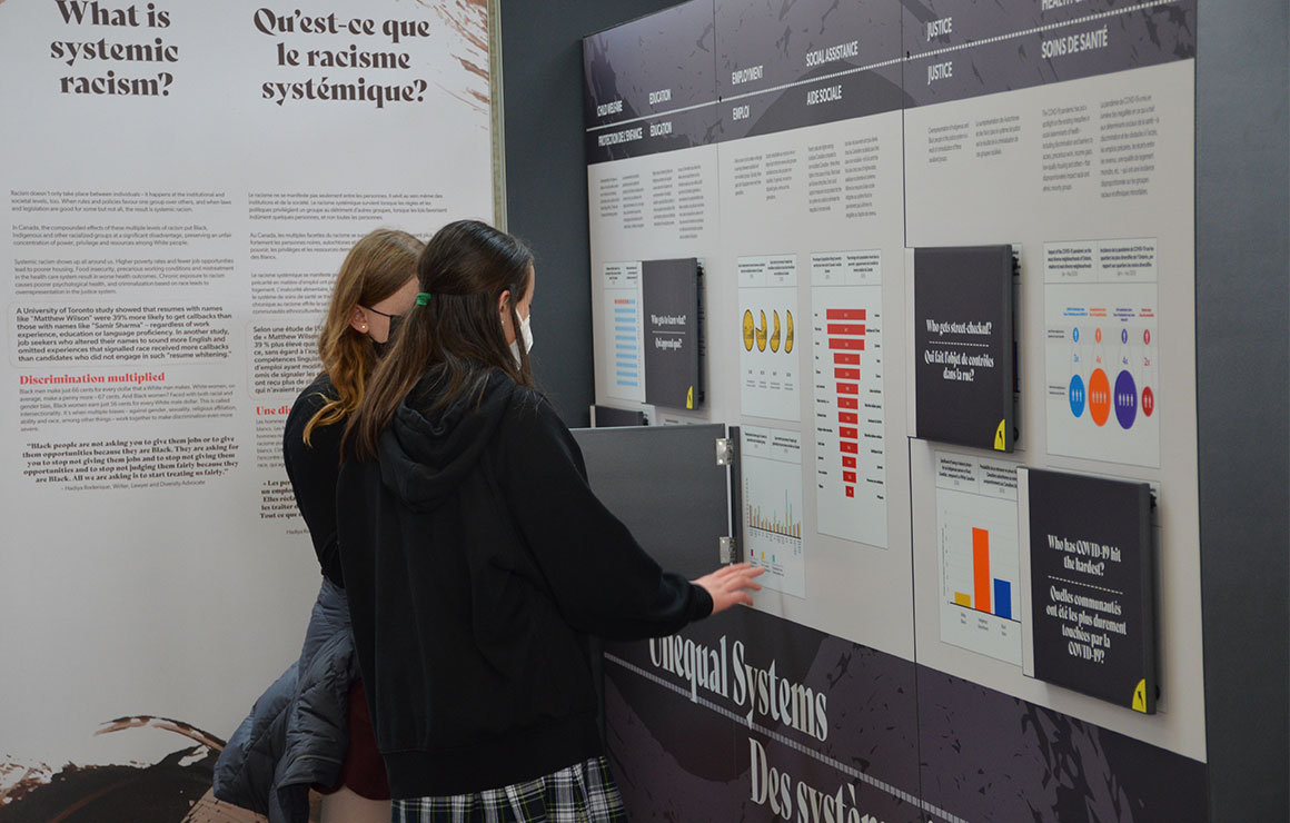 Two people reading panels of information.