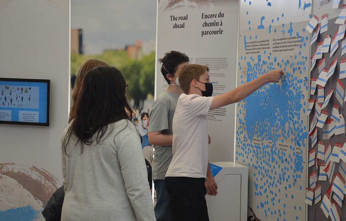 People placing stickers on an exhibit.