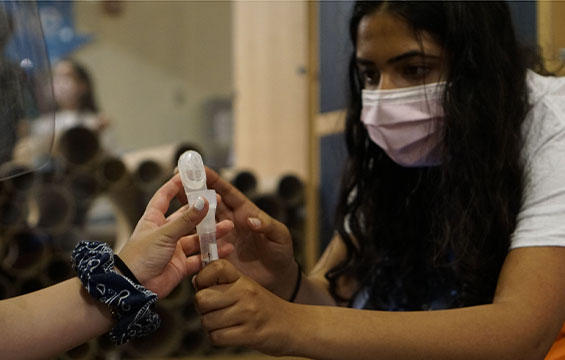 A woman holding a vial.