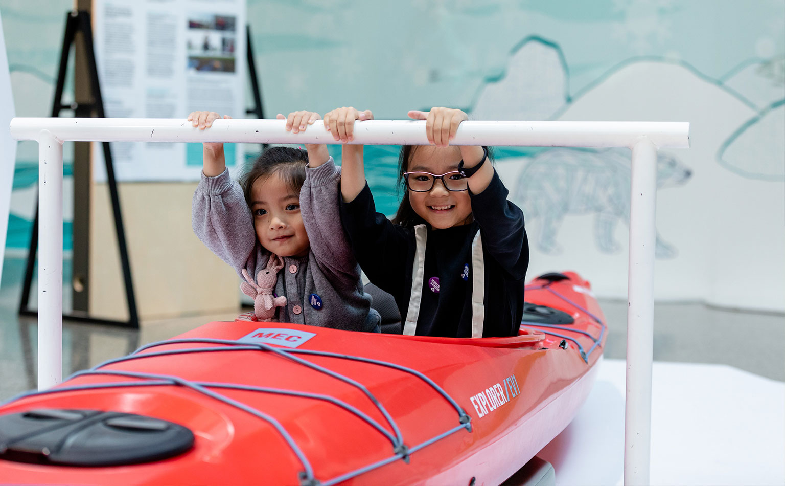 Two children in a kayak learn about its history.