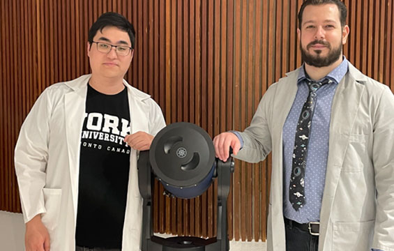 Two men with a piece of scientific equipment.