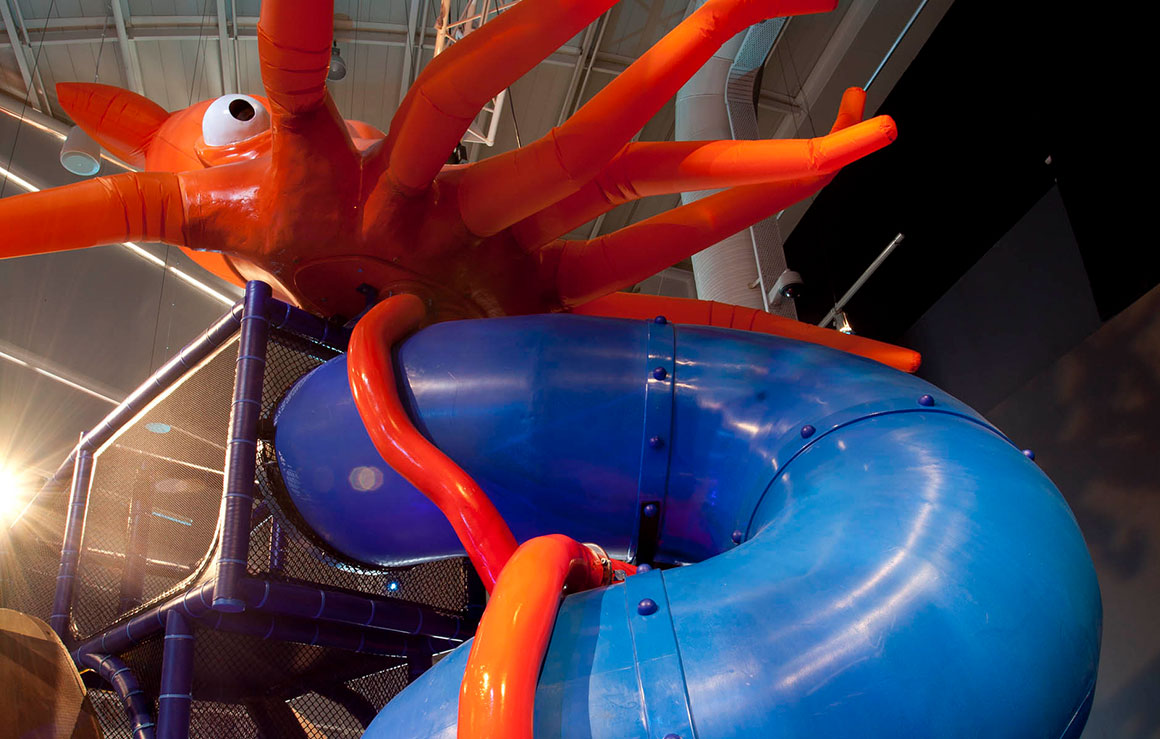 A giant octopus on top of a curvy slide.