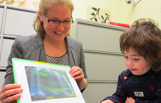 A woman and child look at a book together.