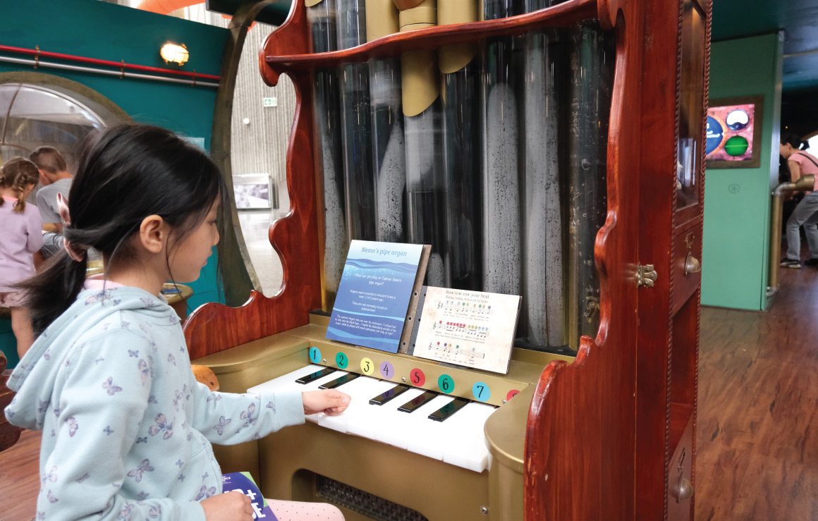 A child plays a small pipe organ in the exhibition.