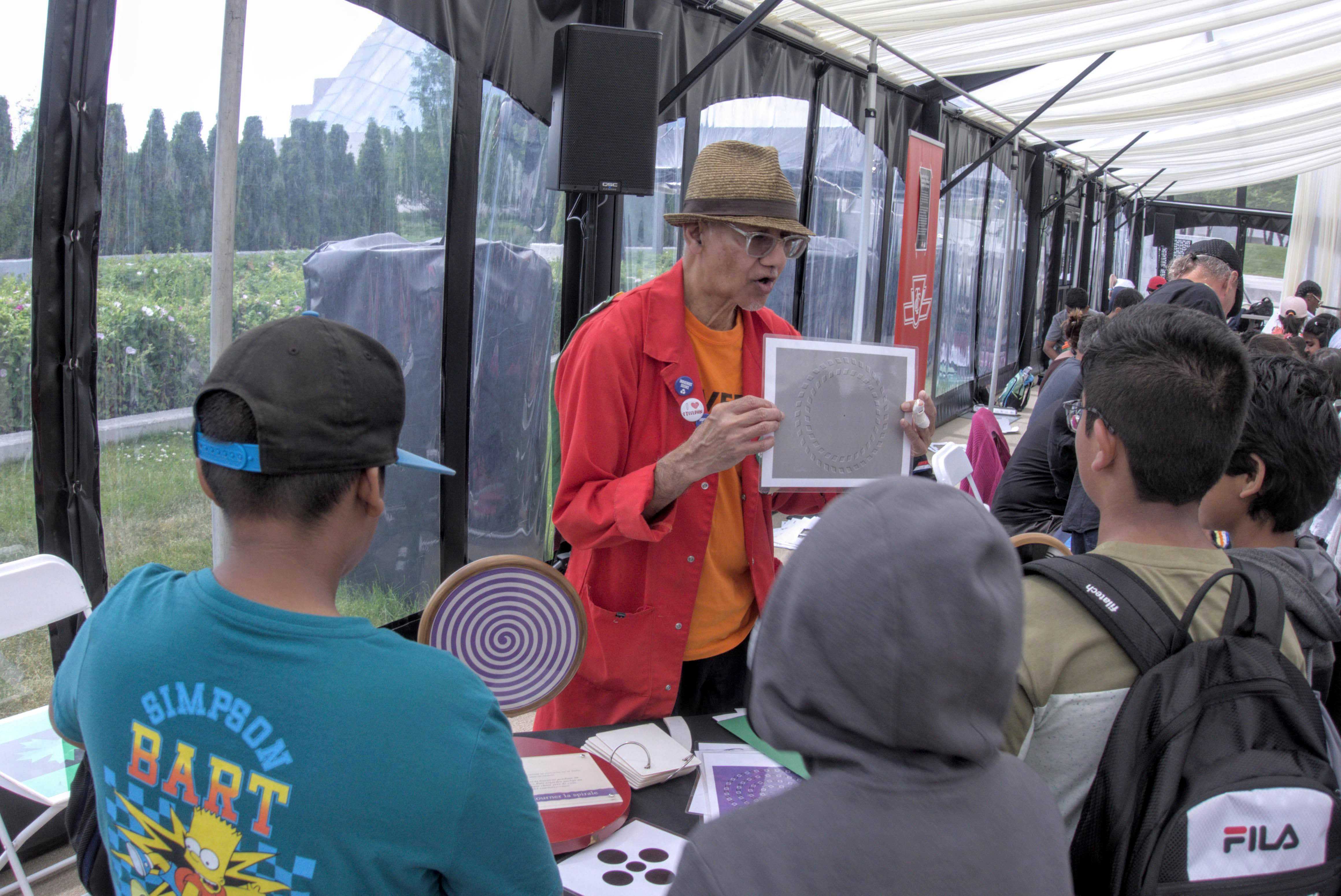 Five people stand at a science centre booth.