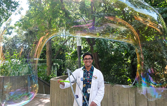 A host uses a wand to make a giant bubble.