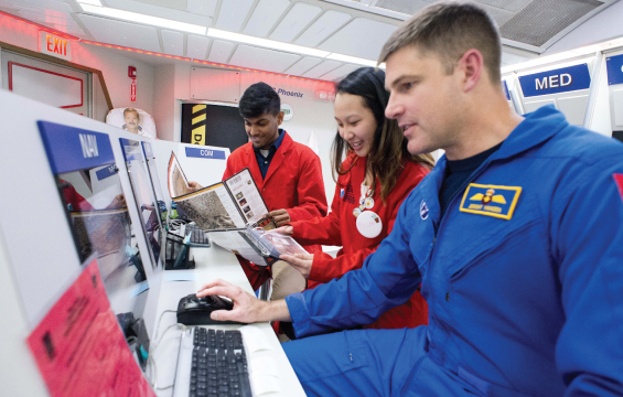 A Mission Commander works with two students in the Spacecraft