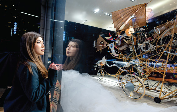 A woman looks through a window at a Dream Machine.