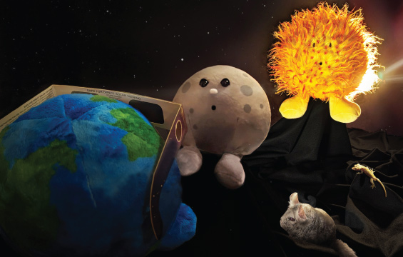 Stuffed toys of the Earth, the Moon and the sun demonstrate a solar eclipse