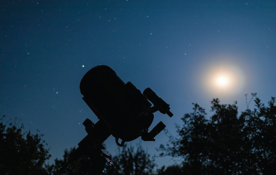 Silhouette of a telescope against the night sky.