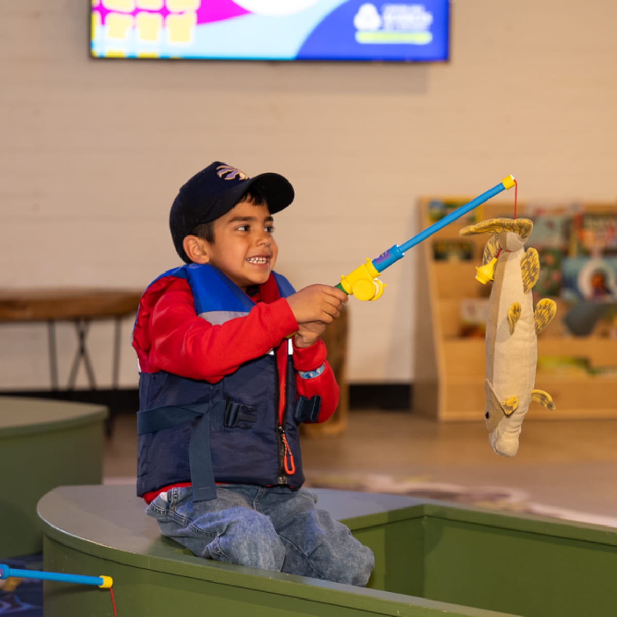 A boy with a fishing rod at the pond.