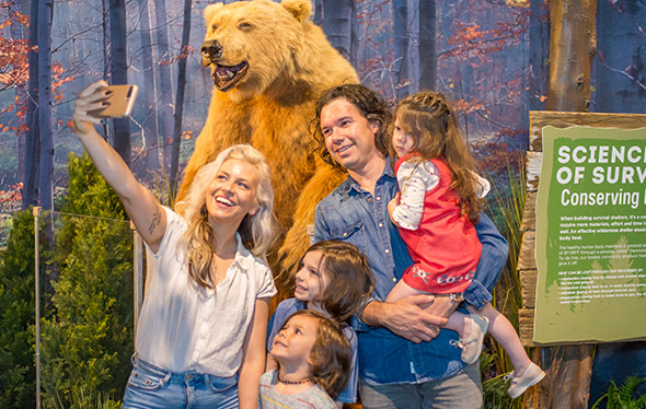 A family takes a selfie with a bear.